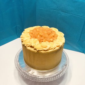 Tall, four-layered fruit cake with whipped cream frosting