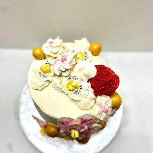 Tall, four-layered fruit cake with whipped cream frosting