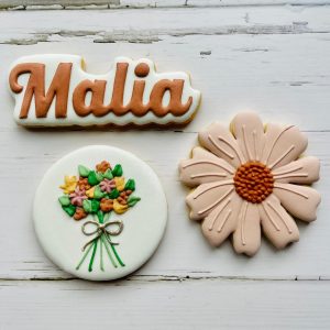 Custom decorated sugar cookies arranged on a plate.