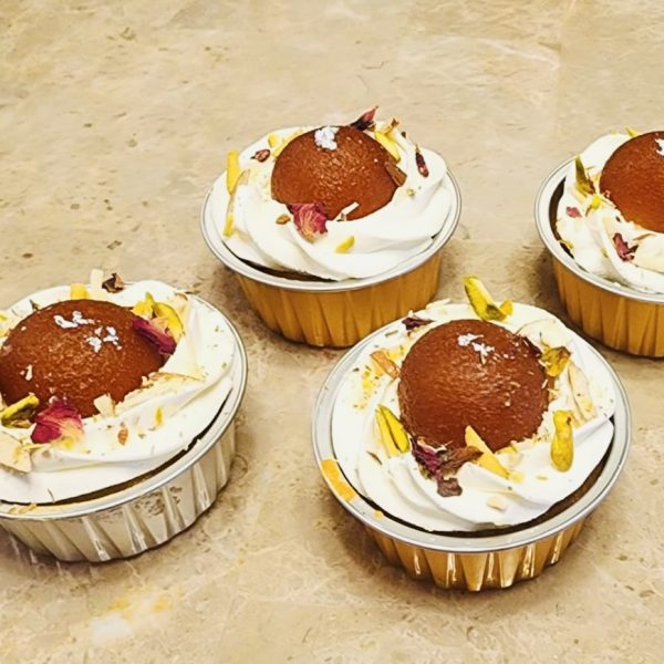 Eggless large fusion cupcakes with Indian flavors and nut toppings.