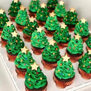 Christmas tree cupcakes with white, red, and green swirls.