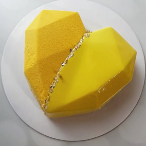 Heart-shaped custom mousse cake with mirror glaze and gold accents.