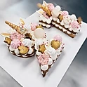 Cookie-like Number Cakes by V with piped cream and customizable decor.