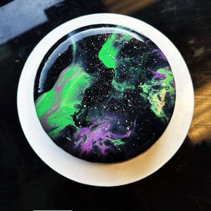 Galaxy-inspired mousse cake with vibrant colors and gold accents