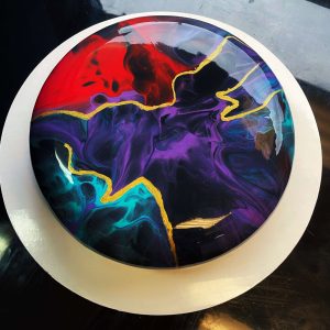 Galaxy-inspired mousse cake with vibrant colors and gold accents