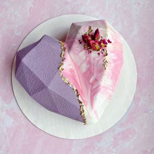 Pink and lavender geometric mousse cake with gold accents.