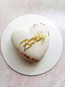 Heart Custom Mousse Cake by V Heart-shaped custom mousse cake with mirror glaze and gold accents.