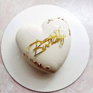 Heart-shaped custom mousse cake with mirror glaze and gold accents.