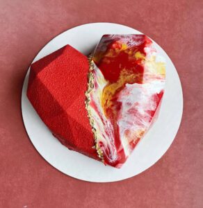 Variation-1 | Heart Custom Mousse Cake by V Heart-shaped custom mousse cake with mirror glaze and gold accents.