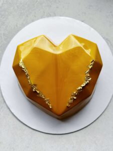 Variation-2 | Heart Custom Mousse Cake by V Heart-shaped custom mousse cake with mirror glaze and gold accents.
