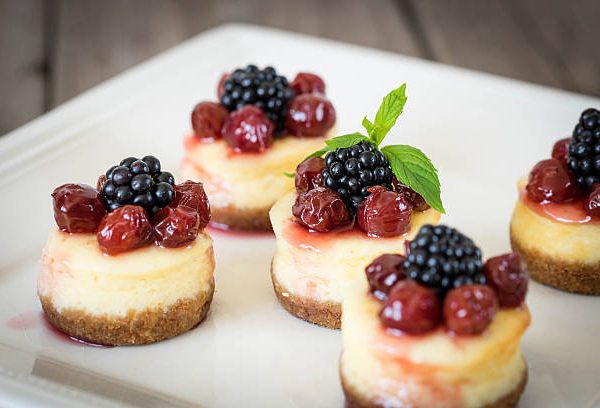 Mini cheesecake with cherry and blackberry on a plate for your design